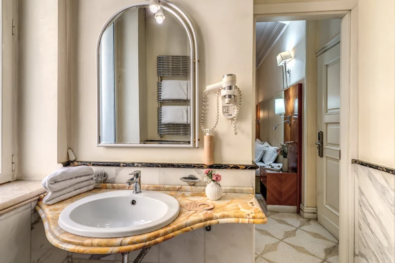 Bagno con lavabo in marmo, specchio ampio e asciugamani vicino Teatro dell’Opera Roma - Depandance Opera, BZAR hotels a Roma