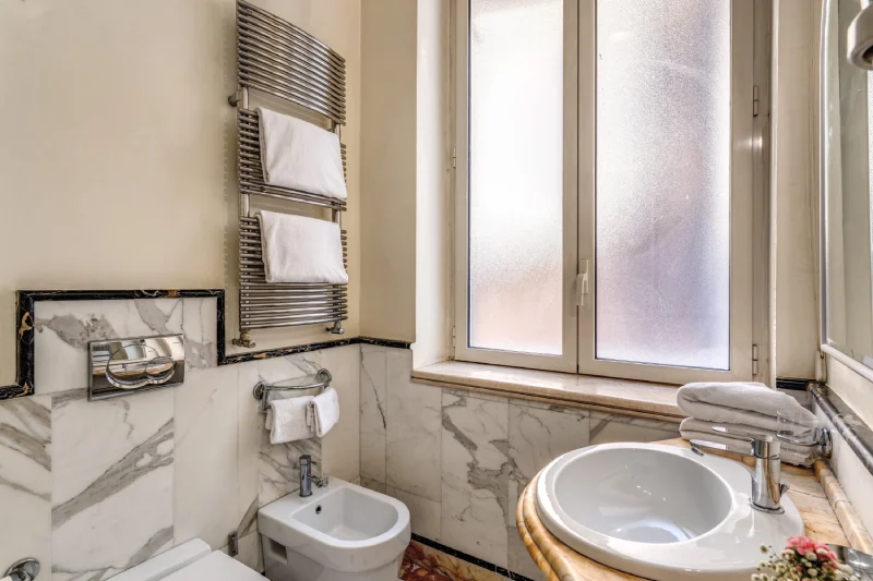 Bagno luminoso con finestra, bidet e dettagli in marmo in struttura vicino Teatro dell’Opera Roma - Depandance Opera, BZAR hotels a Roma
