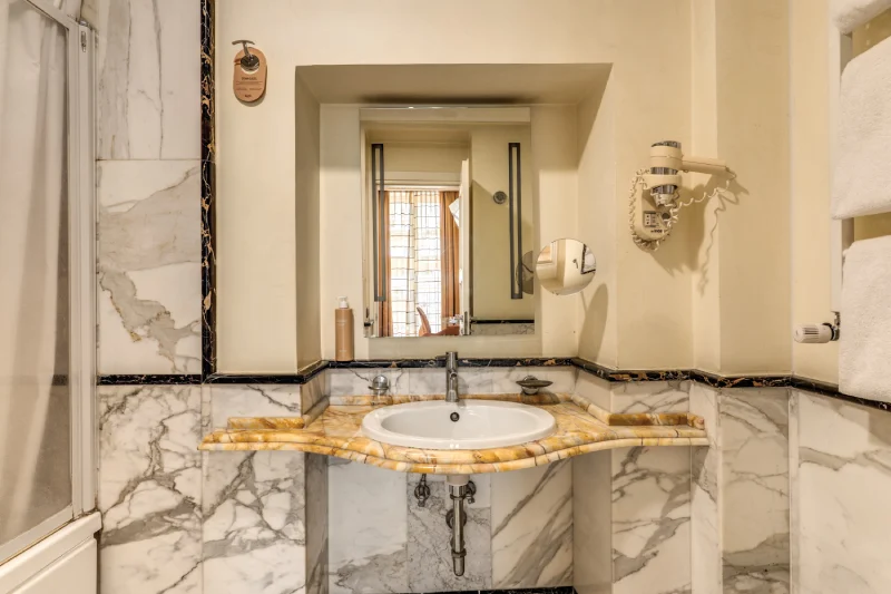 Bagno privato con lavabo in marmo, grande specchio incassato e asciugacapelli vicino Teatro dell’Opera Roma - Depandance Opera, BZAR hotels a Roma