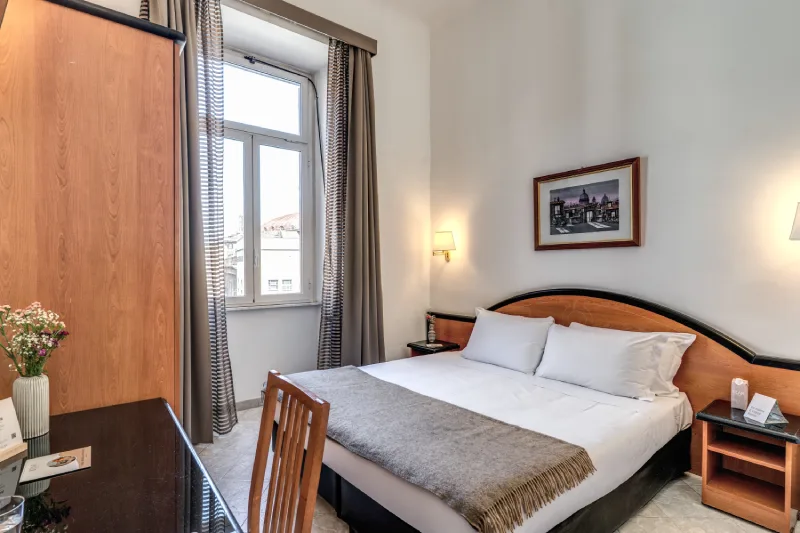 Camera tripla luminosa con letto matrimoniale, arredi in legno e finestra su Roma centro a pochi passi dal Teatro dell’Opera - Hotel Sonya, BZAR hotels a Roma