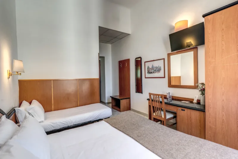 Camera tripla con letti, TV e scrivania, dettagli caldi e funzionali per soggiorni in Roma centro vicino Teatro dell’Opera - Hotel Sonya, BZAR hotels a Roma